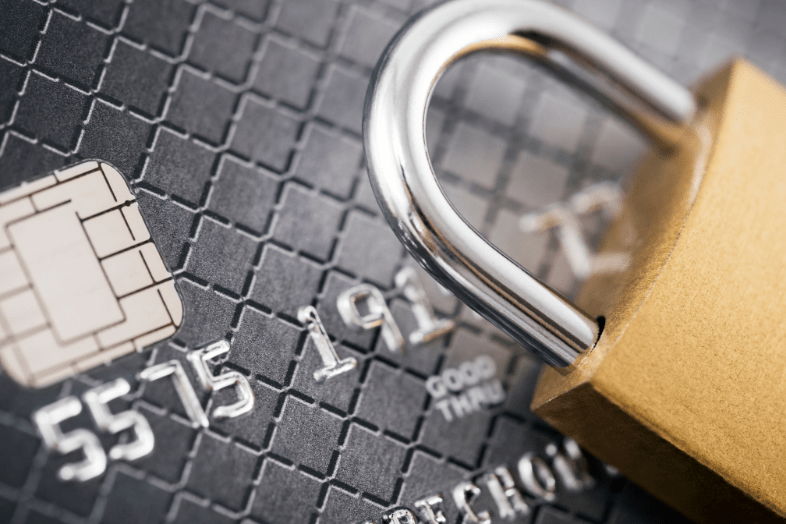 A closeup of a credit card with a locked padlock sitting on top of it